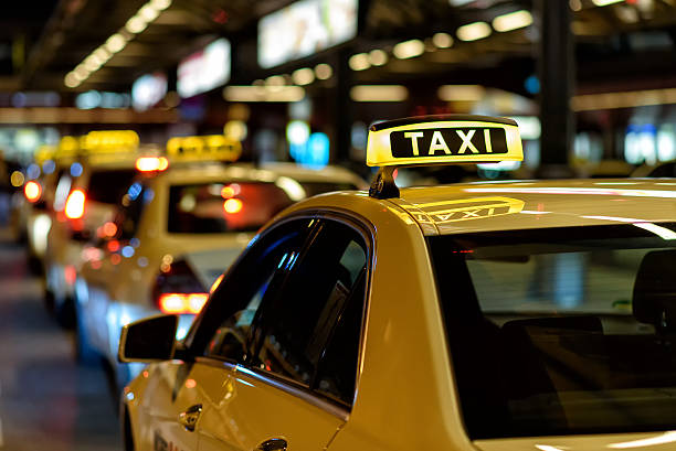 Ряд таксі з підсвіченим знаком TAXI у нічному місті